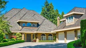 A luxury home with a brown shingle roof.